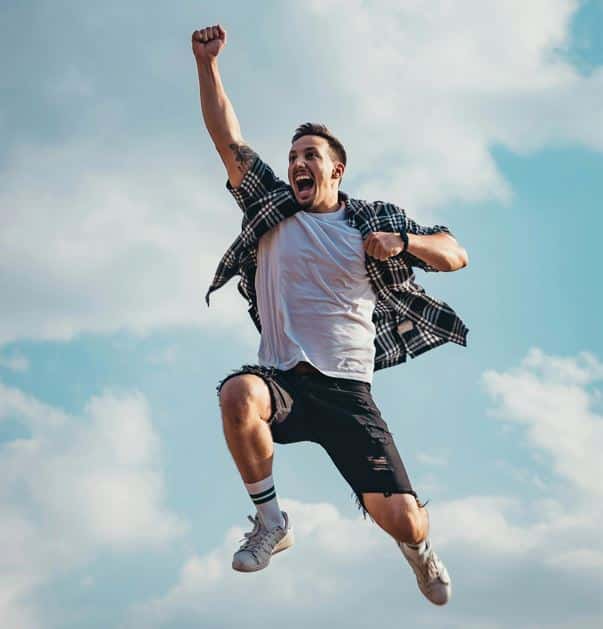 this image shows a person jumping in the air with a fist raised