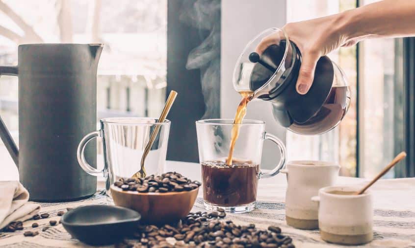 image shows a cup of coffee being poured